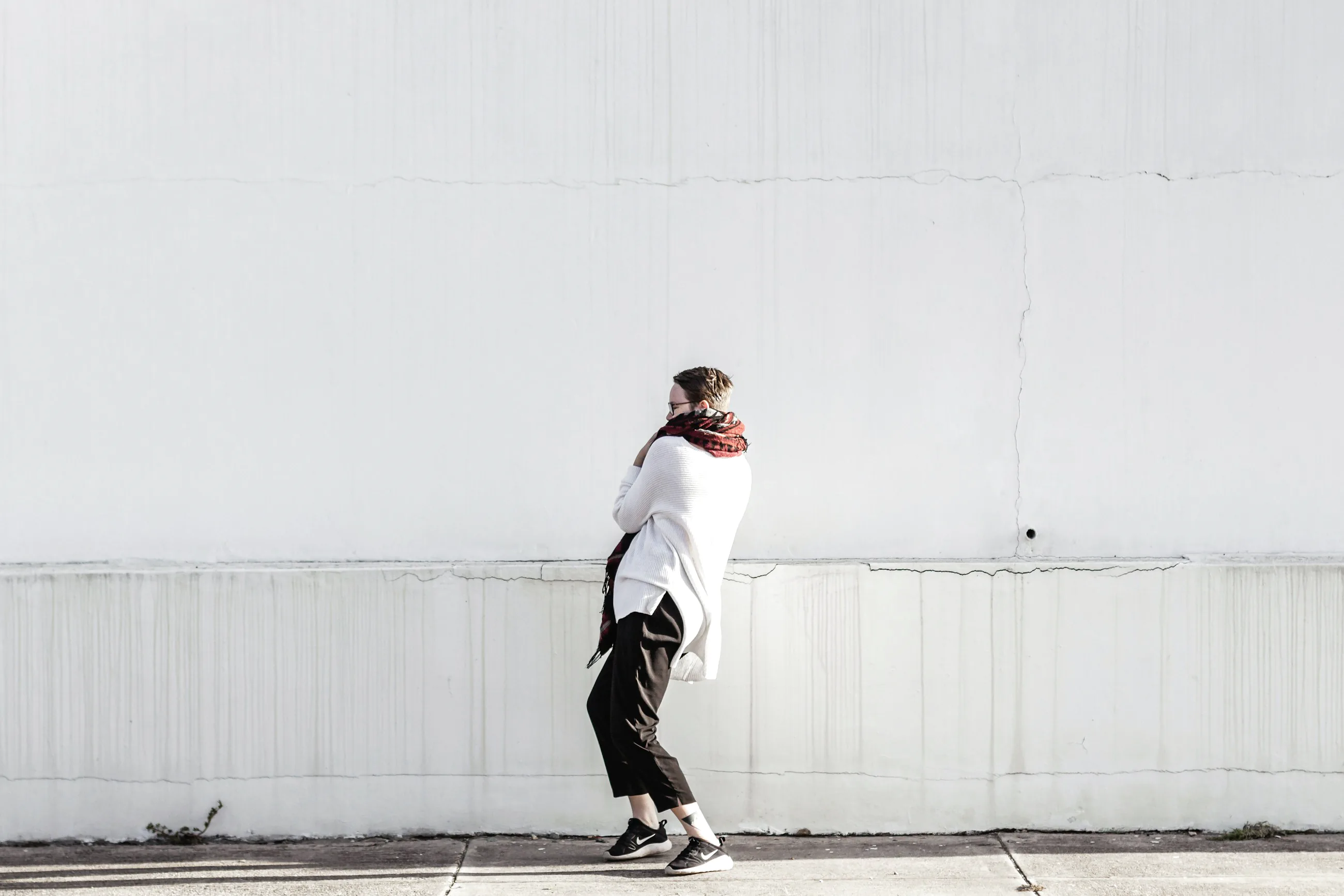 A single figure in a white sweater against a whitewashed wall, Amager
