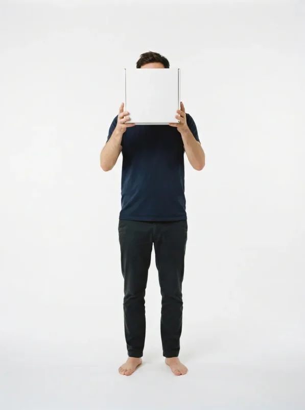 The designer standing on white, a blank carton held in front of the face