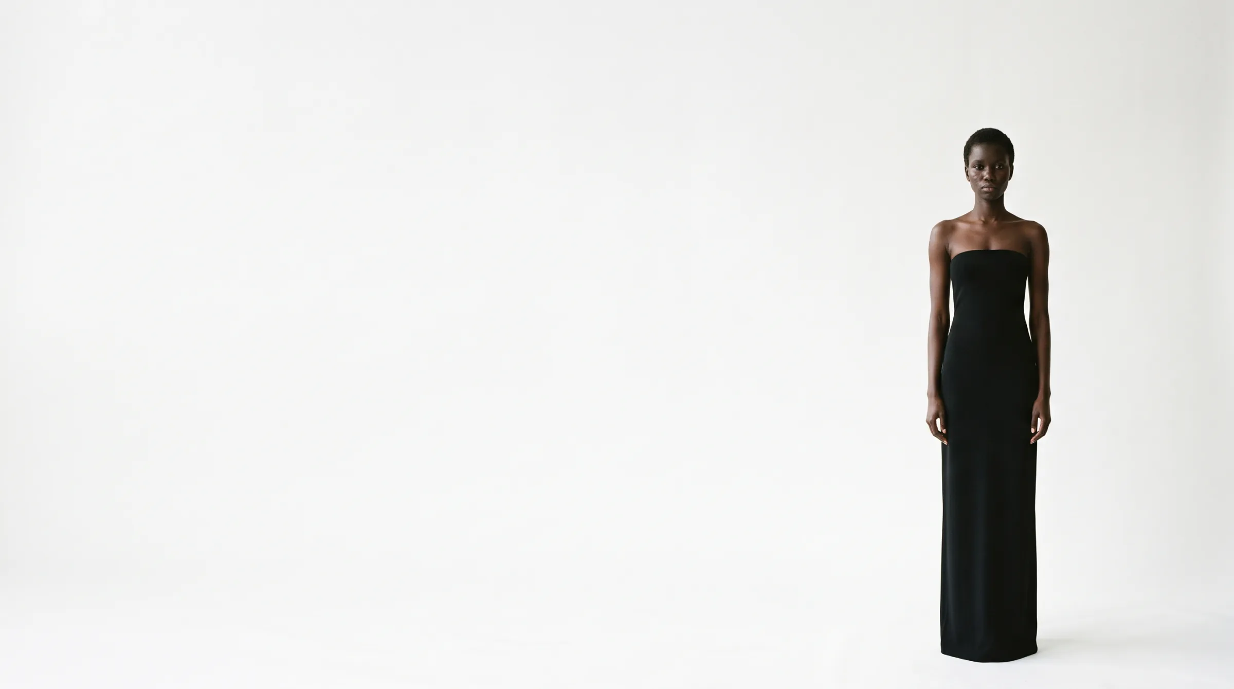 Adama Sène in a black column gown against a white studio backdrop